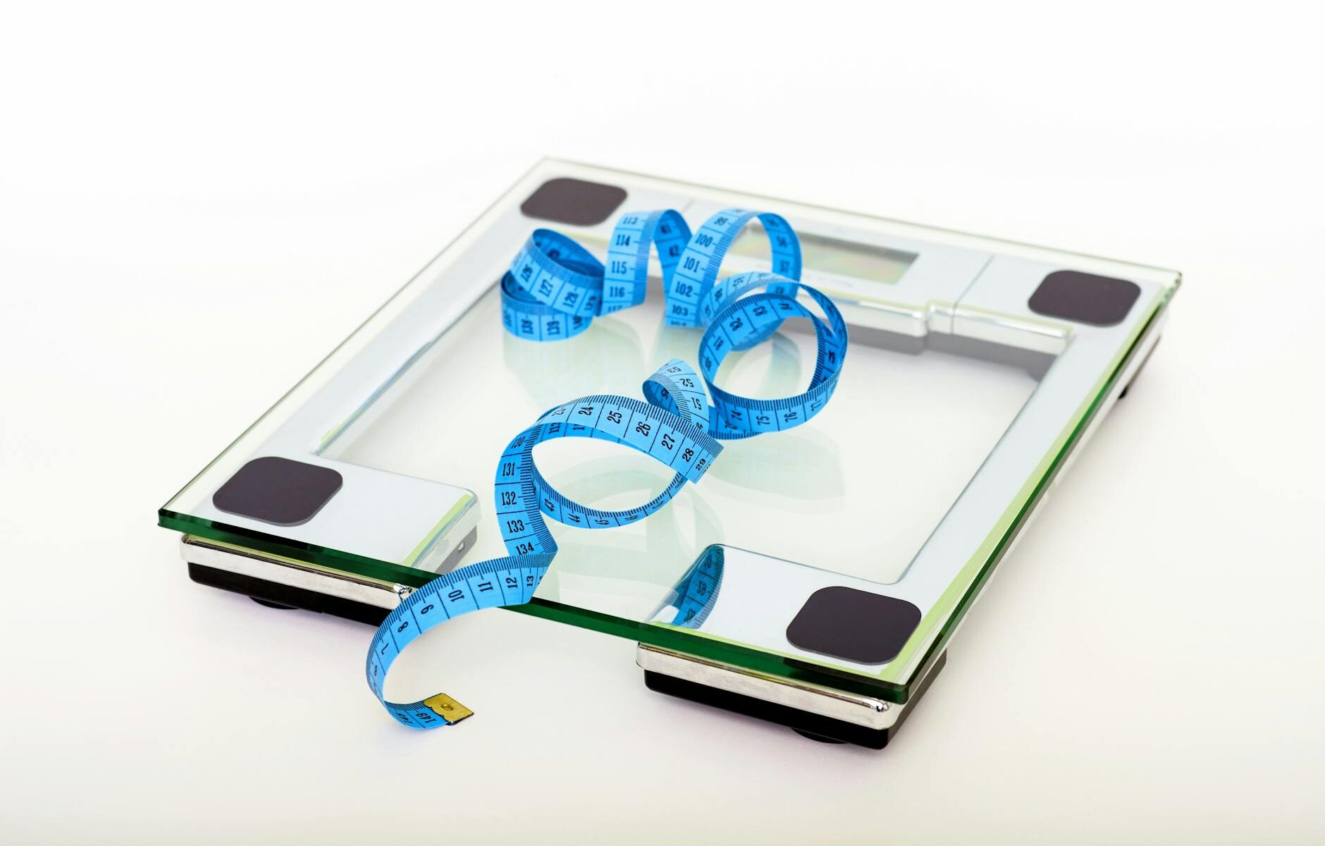 blue tape measuring on clear glass square weighing scale